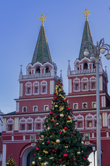 Fototapeta na wymiar The Voskresenskie gate and christmas decorated tree in a dusk. View from Manezhnaya Square.