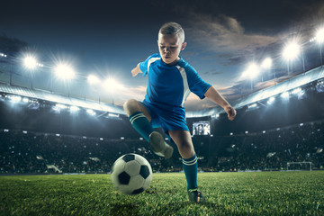 Young boy with soccer ball doing flying kick at stadium. football soccer players in motion on green grass background. Fit jumping boy in action, jump, movement at game. Collage