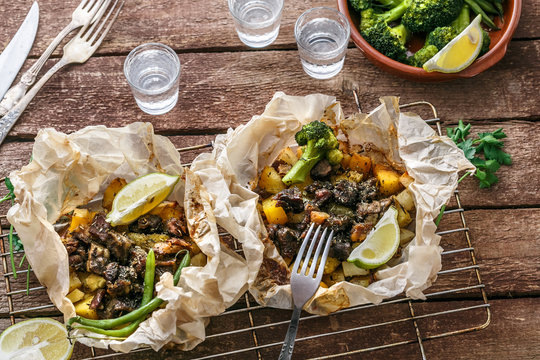 Traditional Greek kleftiko, an oven-baked lamb stew with potato, olive oil, onion, carrot, garlic and herbs, served with lemon and ouzo.