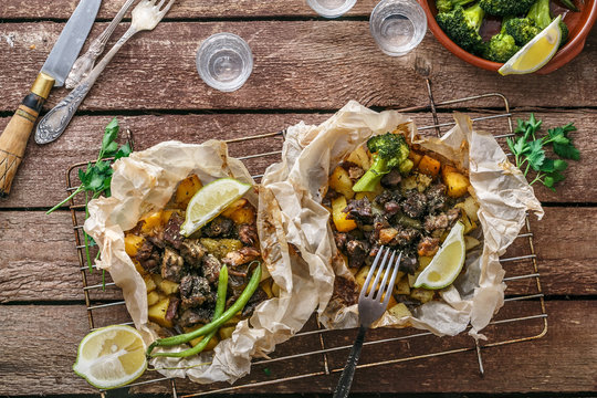 Traditional Greek kleftiko, an oven-baked lamb stew with potato, olive oil, onion, carrot, garlic and herbs, served with lemon and ouzo.