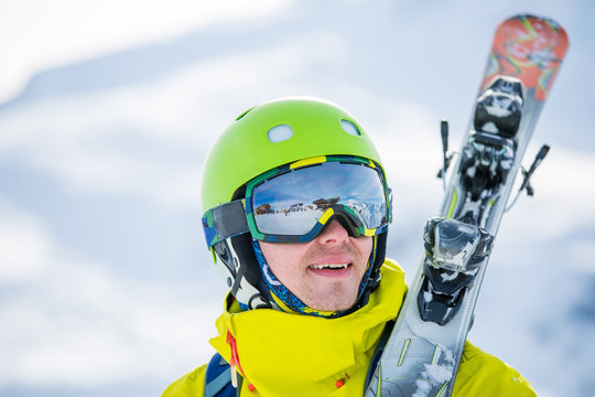 Photo of man wearing helmet wearing glasses with skis