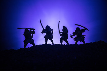 Fototapeta na wymiar Medieval battle scene with cavalry and infantry. Silhouettes of figures as separate objects, fight between warriors on dark toned foggy background. Night scene. Selective focus