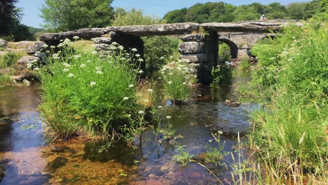 Tilt up to ancient clapper bridge at Postbridge in Dartmoor, UK