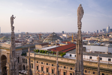 Fototapeta premium Rooftop view of spires, sculpture, cathederal, and Milan from the Duomo di Milano at sunset