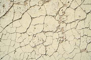 abblätternde Farbe an einer maroden Hauswand mit Rissen 