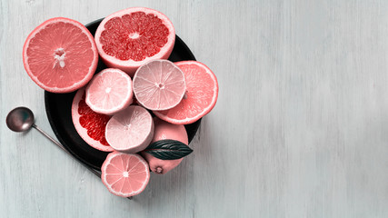 Citrus fruits on white wooden table in cast iron pan. Top view.
