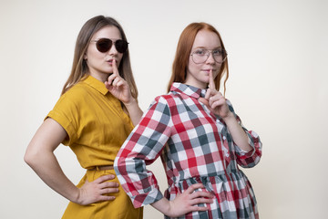 Obraz premium Two beautiful young women showing silence gestures