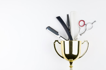 Golden trophy and scissors hairdresser set with various accessories isolated on white background with copy space for your message.Concept winner.