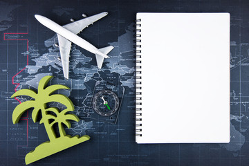 Top view of Blank notebook white paper and passenger plane on world map background with copy space for your message.Business travel transportation system concept.