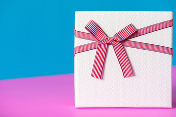 white giftbox with red striped bow for christmas, birthday party