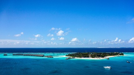 Naklejka na ściany i meble Aerial view of island white sand beach and blue lagoon in Maldives resort.