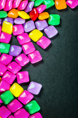chewing gum of different colors on a black background