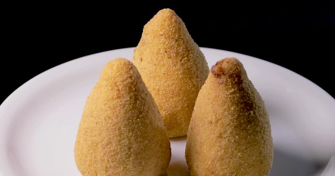 Arancini siciliani su un piatto da esposizione ruotante.