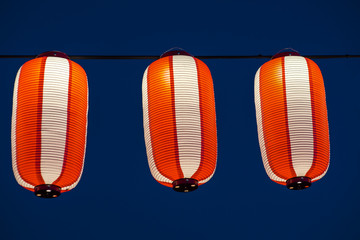 Orange paper lanterns strung in a line on festival