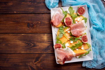 Top view of plate with melon and prosciutto