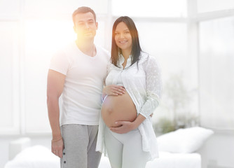 Happy pregnant couple in a new house in a new housing