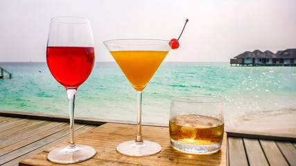 Cocktails on tropical beach vacation, sea background, Maldives.
