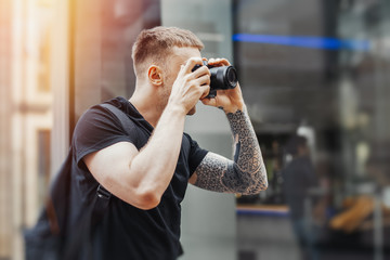 Attractive man making photos outdoors at cityscape background