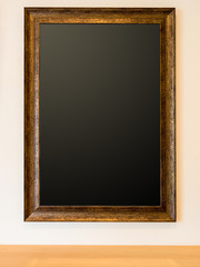 The blank wooden picture frame on the wall