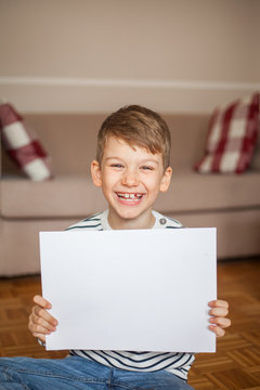 Cute smiling boy holding blank page for copy space