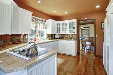 Country kitchen features white cabinets.