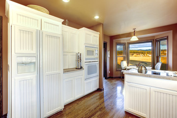 Country kitchen features white cabinets.
