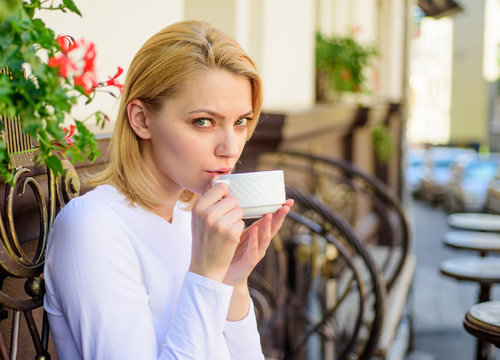 Woman have drink cafe terrace outdoors. Mug of good coffee in morning gives me energy charge. Girl drink coffee every morning at same place as daily ritual. Have sip of hot aromatic beverage