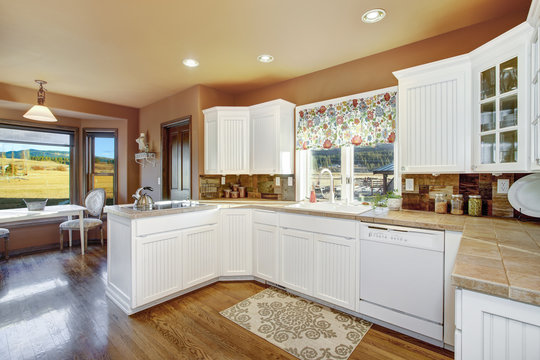 Country kitchen features white cabinets.