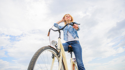 Woman rent bike to explore city copy space. Girl rides bike sky background. Bike rental shops...