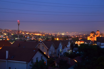 Houses with red roofs in suburban area while night is falling