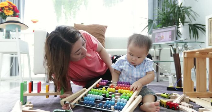 Cute little baby with mom. Mother and son playing education toy. boy and woman playing together.