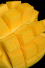 Ripe sliced mango on black background