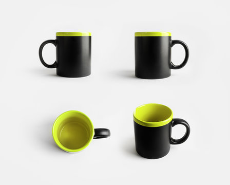 Blank black and light green ceramic mugs. Cups for coffee or tea. Responsive design mockup.