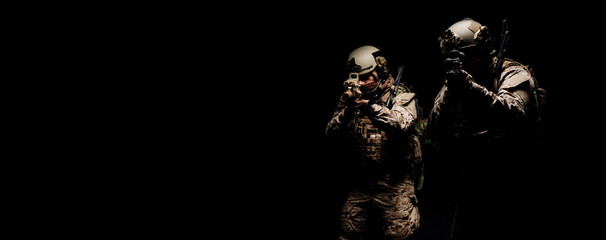 soldiers or private military contractors holding rifle. Image on a black background. war, army,...