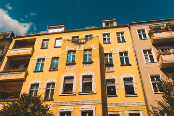Fototapeta na wymiar yellow apartment building with white ornaments and darken sky