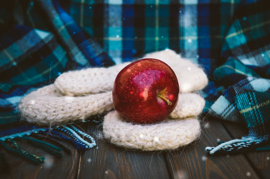 Red apple and warm winter woolen clothes