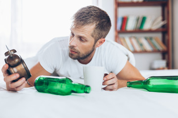 Young man in bed the morning after night out drinking