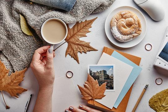 Autumn flat lay concept. Woman’s home office desk with coffee and autumn leaves. Top view