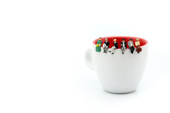 Miniature people : People sitting on cup using for concept of Native American Day.