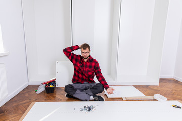 Man putting together self assembly furniture
