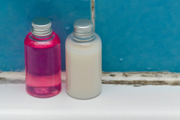 shampoo bottles in a dirty and moldy bathroom