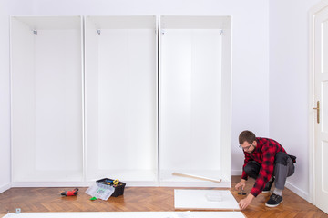 Man putting together self assembly furniture
