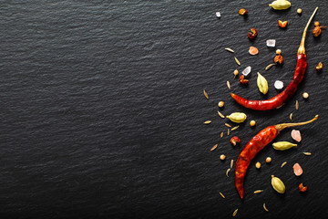 Food spicy presentation background red dried chili and various exotic spieces on black slate board