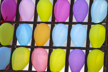 Multi-colored balloons in the cells. Inflatable multi-colored balls in the wood cells for playing darts, close up, entertainment  for adults and children.