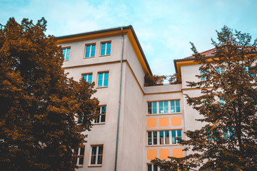 orange apartments with autumn trees and darken sky