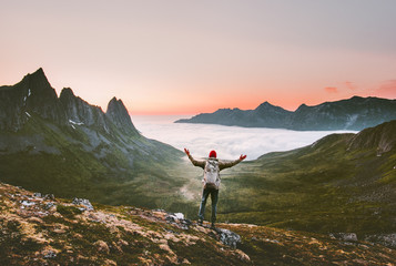 Tourist man with backpack hiking in mountains alone vacations outdoor active lifestyle travel adventure sunset Norway landscape - obrazy, fototapety, plakaty