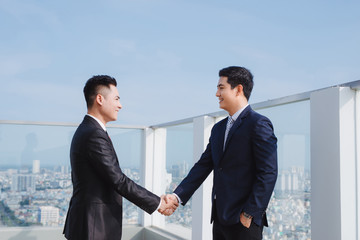 two handsome businessmen greeting each other in the street
