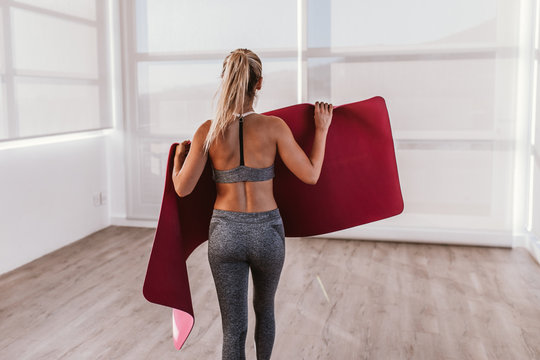young woman preparing fitness mat for excercise