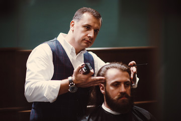 Barbershop with wooden interior. Bearded model man and barber.