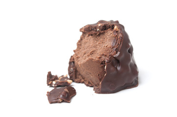 closeup of broken milk chocolate in shaped rock on white background